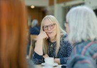 Female resident enjoying a hot drink with other residents