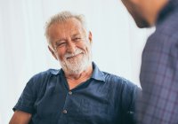 Male resident smiling at a friend conversing