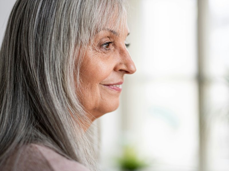 Elderly woman looking out of a window