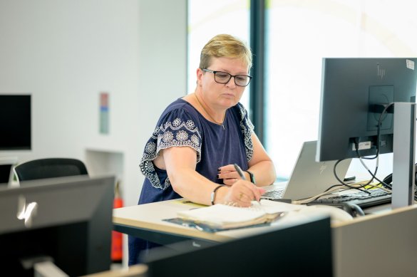 Female staff member making a note in the office