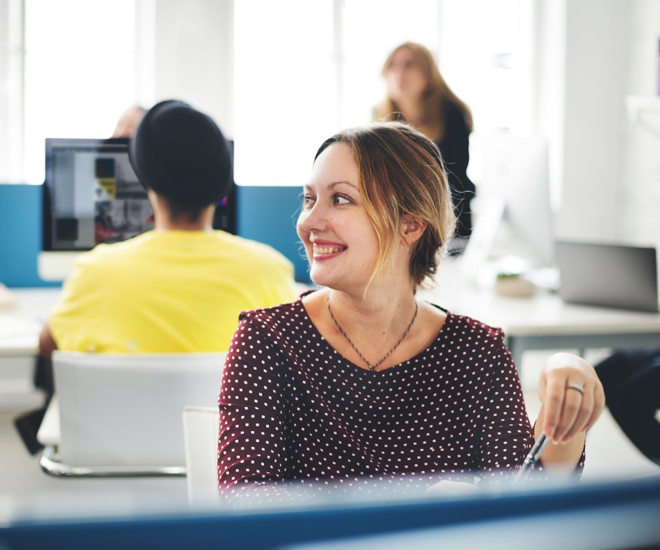 female staff smiling working on the computer